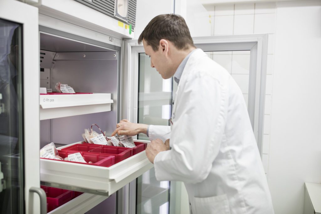 A male scientist checks samples from the custom scientific freezer