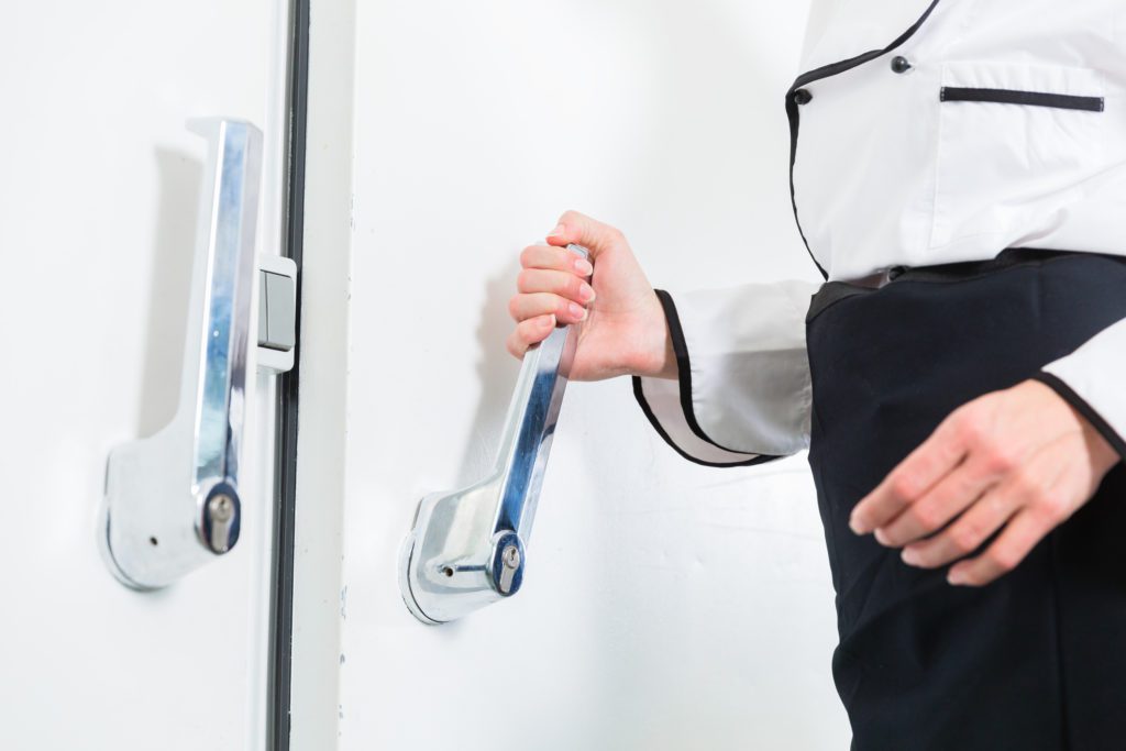 A man holding a beverage storage fridge handle