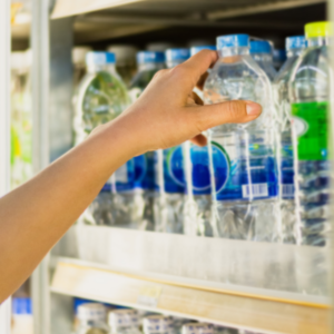 woman's hand pick product from convenience store refrigerator shelves