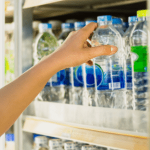 woman's hand pick product from convenience store refrigerator shelves